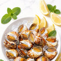 Chilled spotted sea snails on ice with lemon and mint